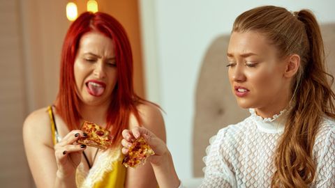 Zwei Frauen ekeln sich vor ihrer Pizza