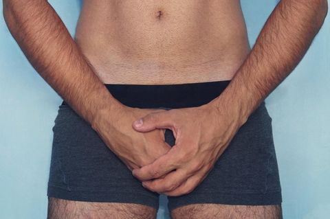 Mann hält sich Hand für vor den Penis