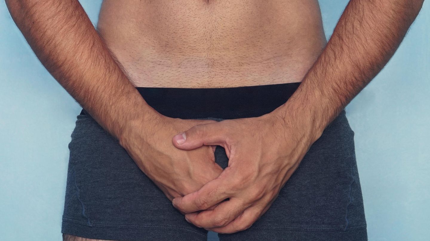 Mann hält sich Hand für vor den Penis