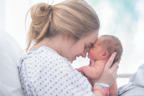 Eine Mutter hält glücklich ihr Neugeborenes im Arm