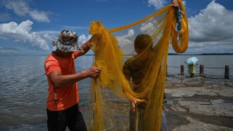 Fischer in der chinesischen Provinz Xiamen bringen ihre Netze aus.