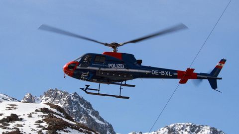 Ein Rettungshubschrauber fliegt über die Alpen