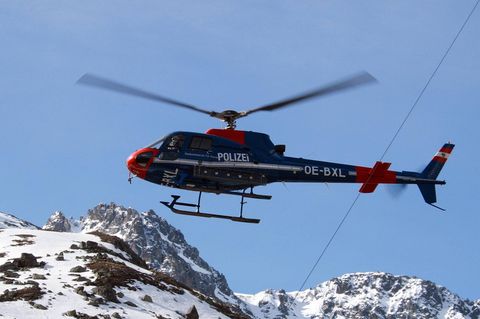 Ein Rettungshubschrauber fliegt über die Alpen
