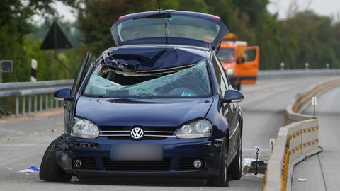 Ein dunkelblauer VW steht mit zerschmetterter Windschutzscheibe auf der linken Spur einer Autobahn