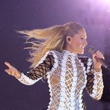 Helene Fischer singt mit wehendem Haar in ein Mikro, während im Hintergrund Regentropfen glänzen