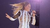Helene Fischer singt mit wehendem Haar in ein Mikro, während im Hintergrund Regentropfen glänzen