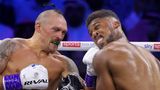 Ein weißer Boxer trifft mit links seinen schwarzen Gegner am Unterkiefer