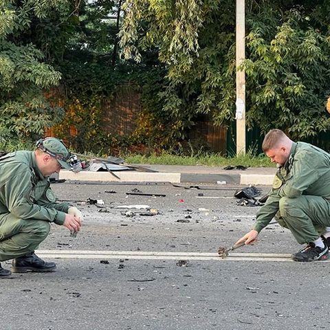 Ermittler am Ort der Explosion eines von Daria Dugina gefahrenen Autos außerhalb von Moskau