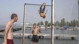 Mykolajiw, Ukraine. Hoffentlich können sie bei ihrem Spiel den Krieg für eine Weile vergessen: Kinder und Jugendliche in der umkämpften Hafenstadt zeigen beim Baden im Fluss ihre akrobatischen Künste.