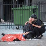 Eine Polizistin tröstet den Vater eines 13-jährigen Jungen, der bei einem russischen Angriff in Charkiw getötet wurde