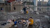 Chongqing, China. Bewohner der südwestchinesischen Millionenmetropole nutzen, was vom Jialing-Fluss übrig ist, um sich abzukühlen. Große Teile des Landes erleben derzeit den heißesten und trockensten Sommer seit Beginn der Aufzeichnungen im Jahr 1961.