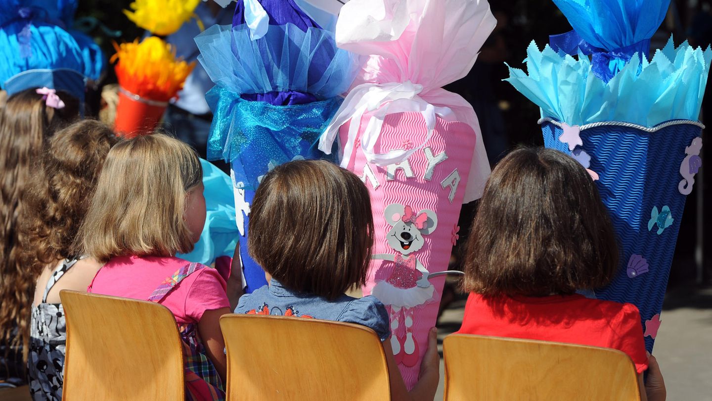 Mädchen halten ihre riesigen Schultüten in der Hand