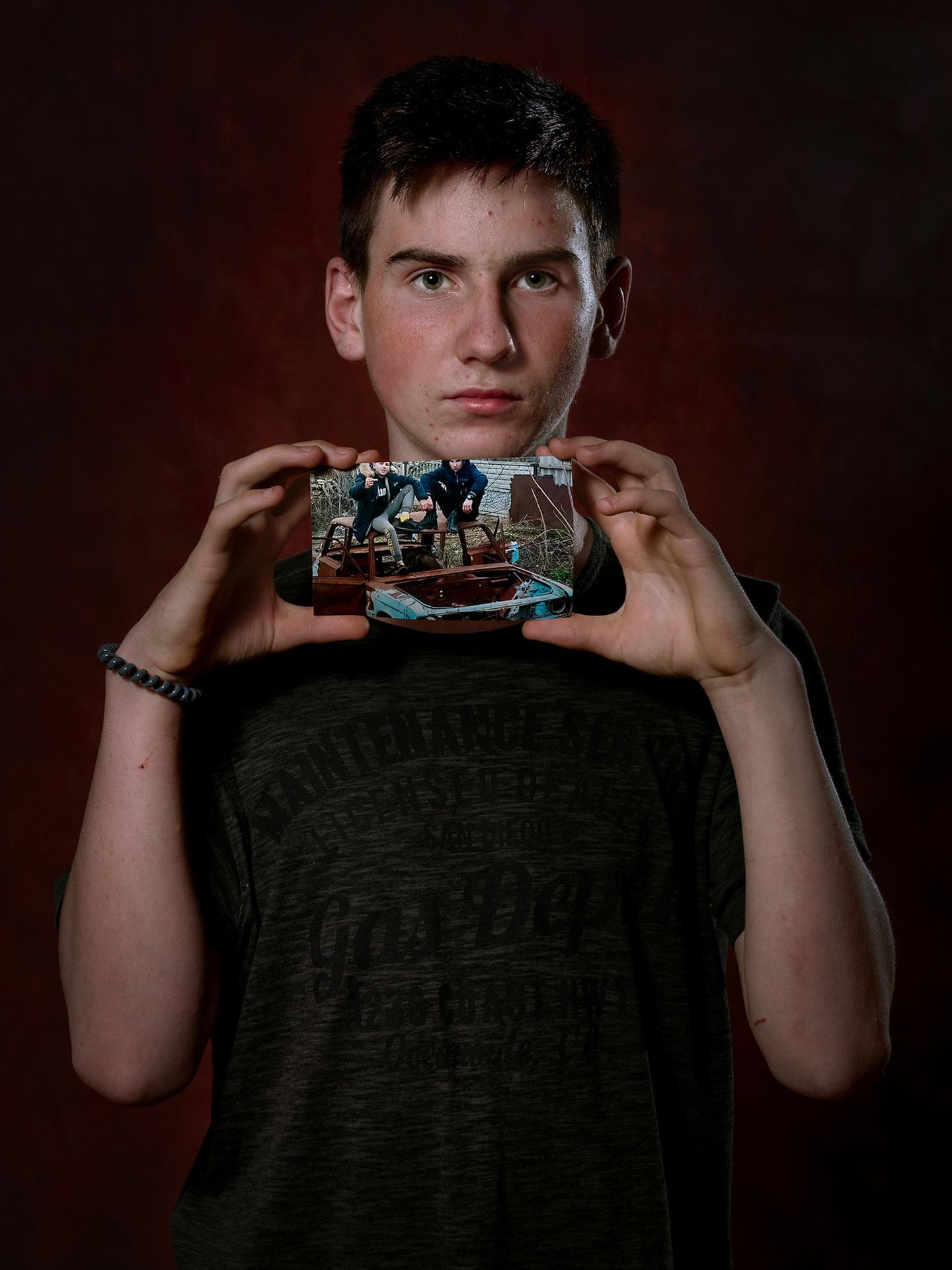 Maxim, 15 Jahre Maxim, aus der Ukraine hält einen Fotoabzug in der Hand