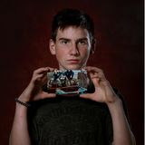 Maxim, aus der Ukraine hält einen Fotoabzug in der Hand