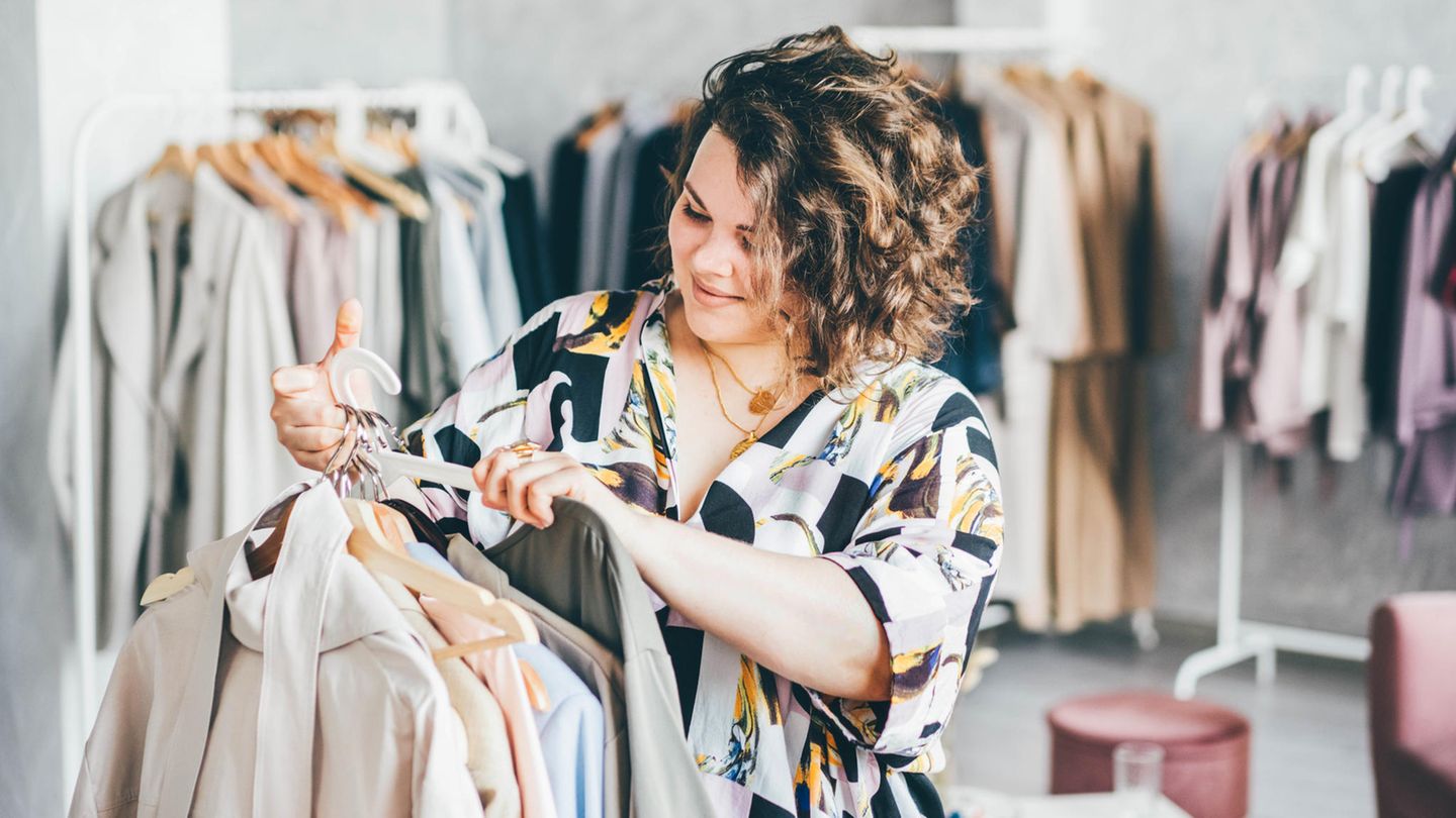 Eine kurvige Frau zeigt sich in ihrem blumigen Oberteil