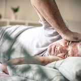 Mann liegt mit Migräne im Bett