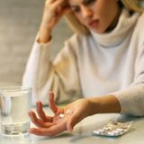 Frau nimmt Schmerzmittel bei Kopfschmerzen