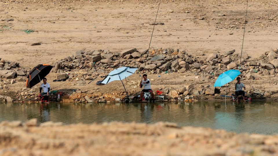 Menschen fischen in einer Pfütze des ausgetrockneten Jangtse-Flussbetts