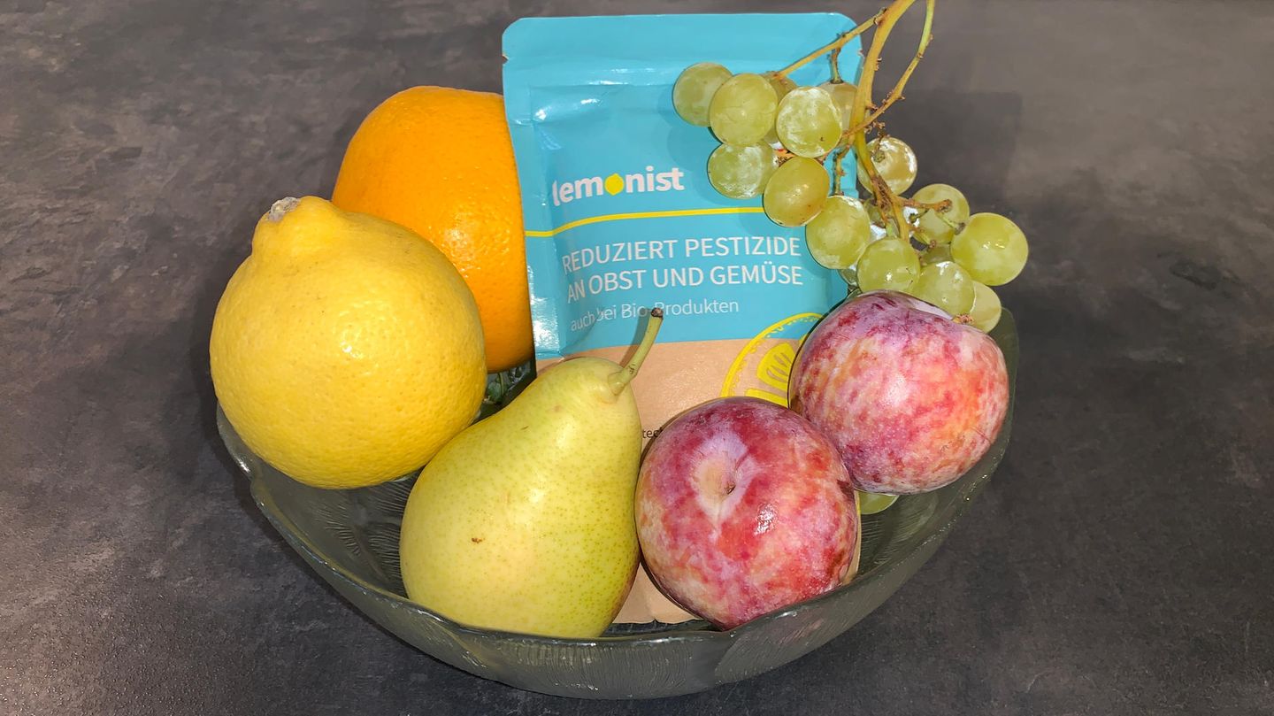 Lemonist aus DHDL liegt in einer Glasschale zwischen Trauben, Pflaume, Birne und Orange.