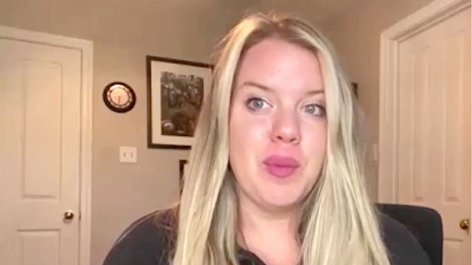 Eine junge weiße Frau mit langen blonden Haaren sitzt in einem Zimmer mit sandfarbenen Wänden und weißen Türen Eine junge weiße Frau mit langen blonden Haaren sitzt in einem Zimmer mit sandfarbenen Wänden und weißen Türen
