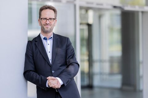 Klaus Müller steht nach einem Interview vor seiner Behörde in Bonn.