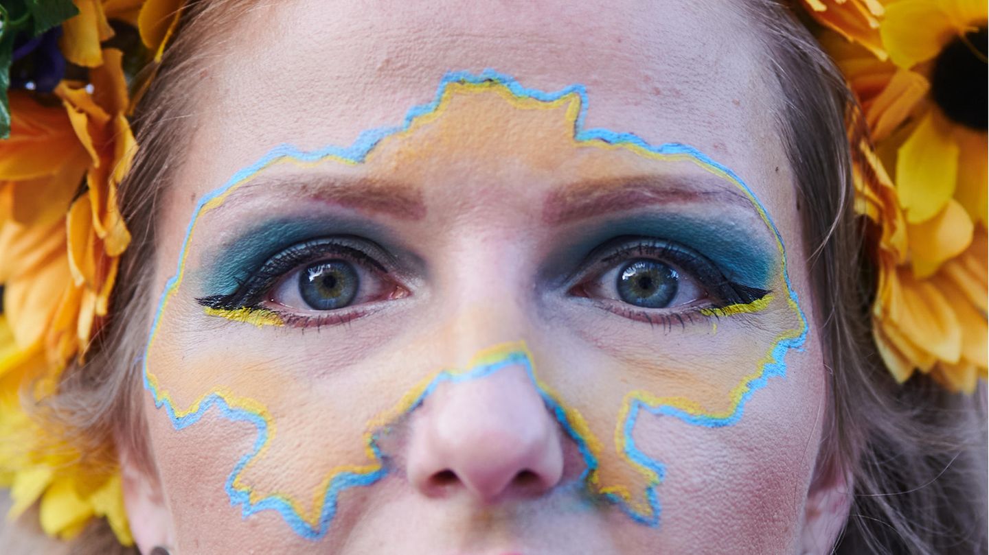 Eine Demonstrantin hat sich den Umriss der Ukraine ins Gesicht gemalt