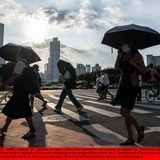 Menschen laufen mit Regenschirmen durch die chinesische Stadt Guangzhou