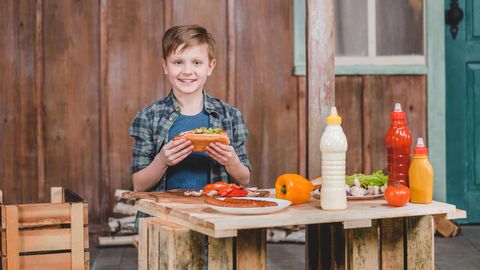 Ein kleiner Junge isst einen Hot Dog