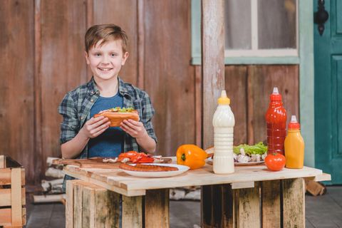 Ein kleiner Junge isst einen Hot Dog