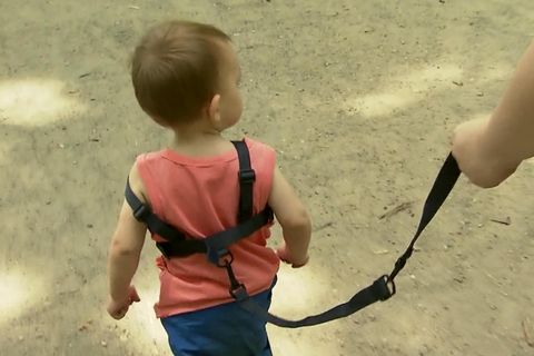 Debatte um Kinder-Erziehung: Kind wird an Leine über Spielplatz geführt