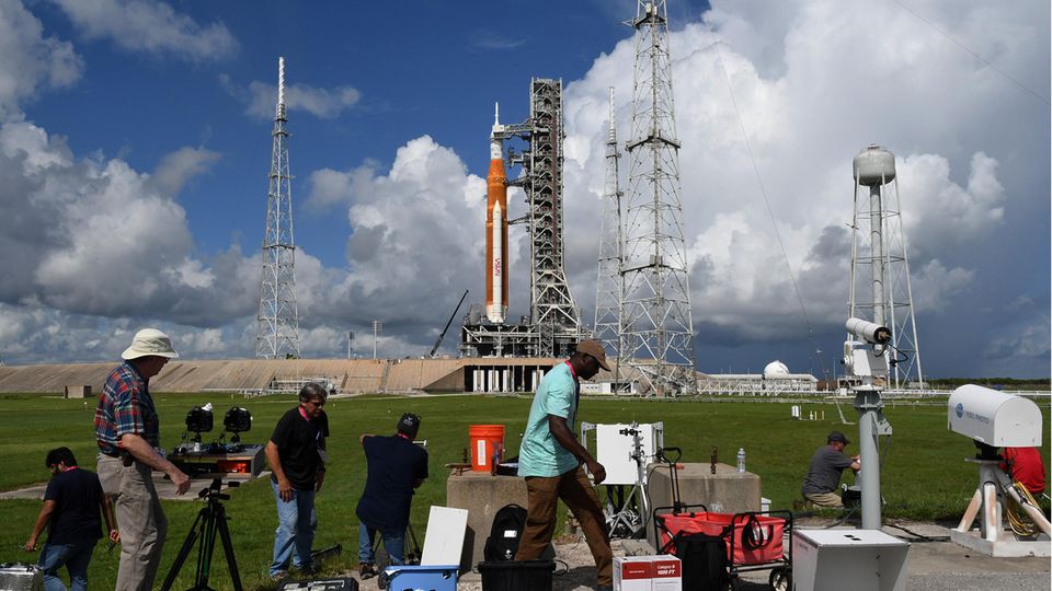 Fotografen stellen ferngesteuerte Kameras auf, als die Artemis-1-Rakete der NASA am 25. August 2022 auf der Startrampe 39-B im Kennedy Space Center in Cape Canaveral, Florida, startbereit gemacht wurde. Die Rakete wird für einen unbemannten Flug um den Mond am 29. August 2022 vorbereitet