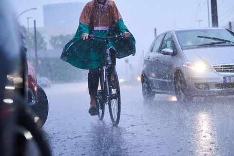 Radfahrer fahren bei starkem Regen durch die Stadt
