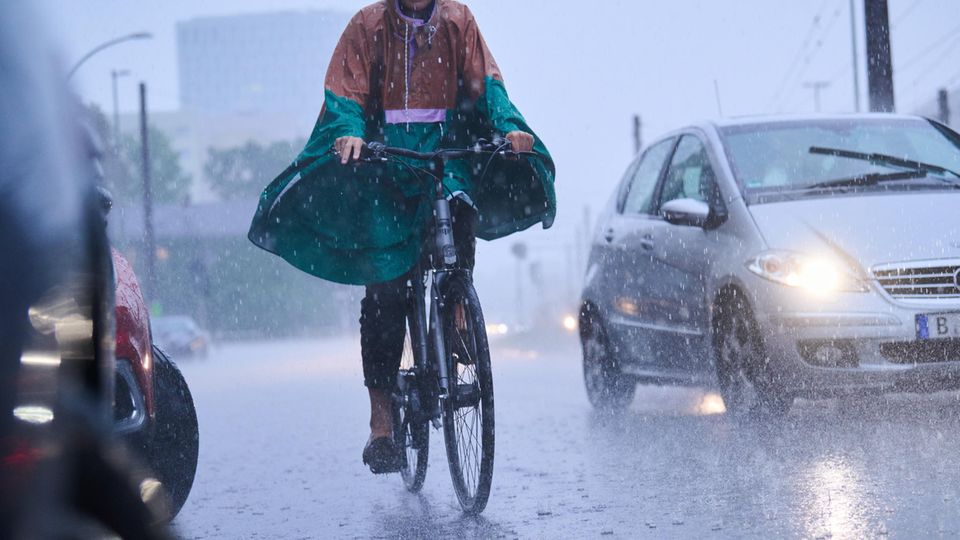 Radfahrer fahren bei starkem Regen durch die Stadt