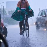 Radfahrer fahren bei starkem Regen durch die Stadt