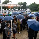 Gäste versuchen unter Schirmen beim Bürgerfest des Bundespräsidenten im Park von Schloss Bellevue ins Gespräch zu kommen