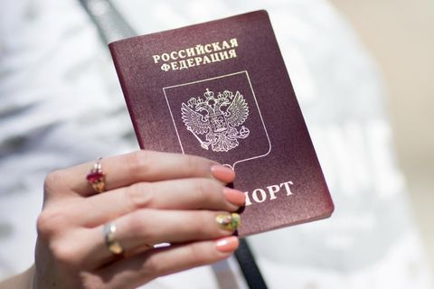 Ein russischer Pass in der Hand einer Reisenden. Europa streitet über ein Visastopp