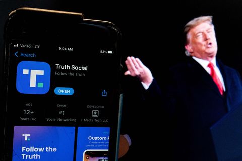 Ein Bild von Donald Trump steht neben der "Truth Social"-App
