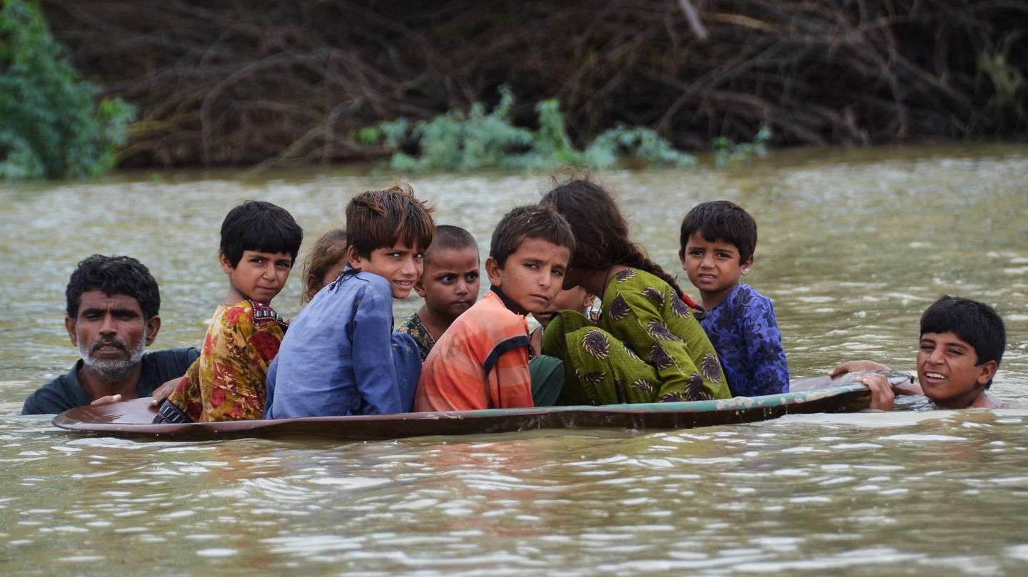 Auf der Flucht vor den Fluten: In der Region Jafarabad transportiert ein Mann Kinder in einer Satellitenschüssel über das Wasser, um sie in Sicherheit zu bringen. In der Region Jafarabad transportiert ein Mann Kinder in einer Satellitenschüssel über das Wasser, um sie in Sicherheit zu bringen.