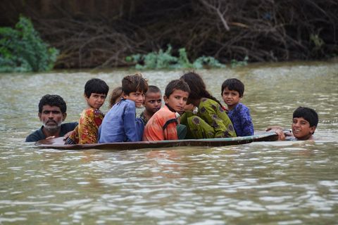 In der Region Jafarabad transportiert ein Mann Kinder in einer Satellitenschüssel über das Wasser, um sie in Sicherheit zu bringen.
