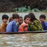 In der Region Jafarabad transportiert ein Mann Kinder in einer Satellitenschüssel über das Wasser, um sie in Sicherheit zu bringen.