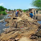 Zwei Männer in der Region Jaffarabad suchen in ihrem von den Fluten zerstörten Haus nach allem, was sich zu retten lohnt. Die Regierung entsendet Soldaten, um den Menschen zu helfen. 