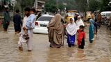 Vertriebene waten in Peschawar über eine überschwemmte Straße. Die Regierung hat den Notstand ausgerufen. Das Problem ist, dass die Regenfälle anhalten.