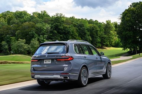 Ein BMW X7 in der seitlichen Rückansicht fährt auf einer Straße
