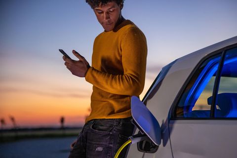 Ein Mann lädt ein Elektroauto an einer Ladesäule