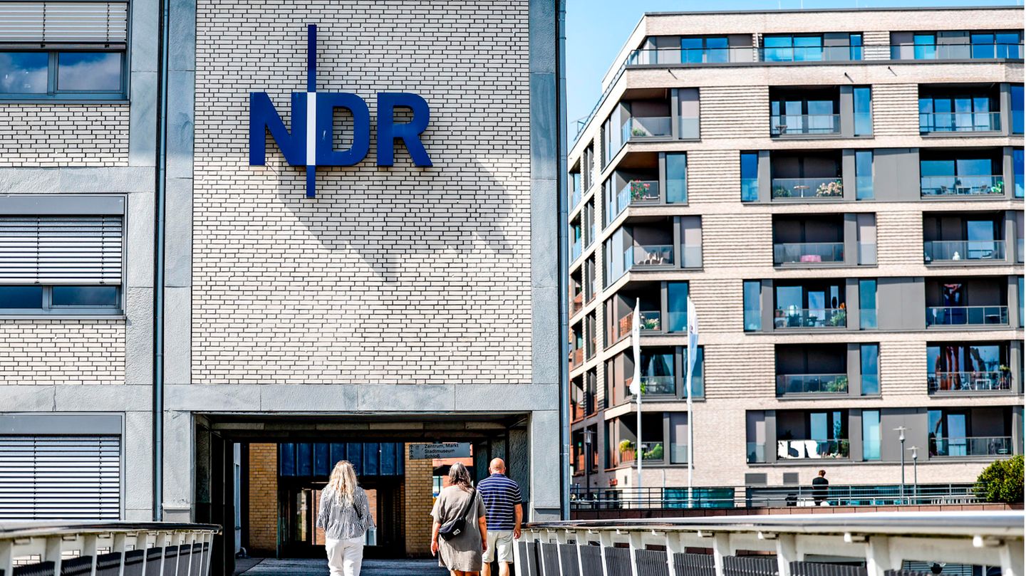 Schleswig-Holstein, Kiel: Passanten gehen vor der Einfahrt zum Landesfunkhaus Schleswig-Holstein des NDR entlang