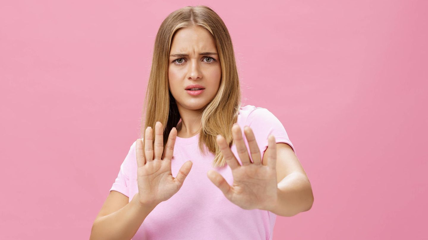 Frau hebt abwehrend die Hände