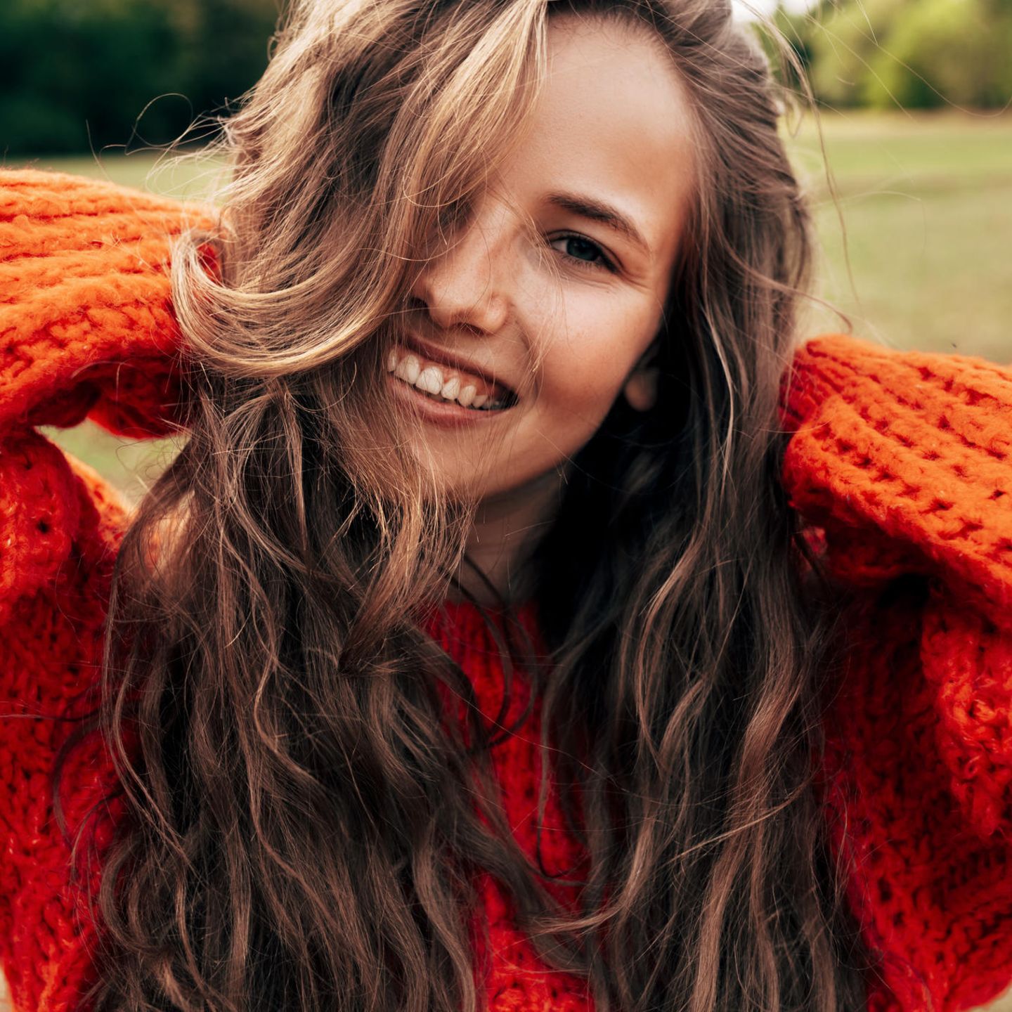 Eine junge Frau mit einem gestrickten orangefarbenen Pullover