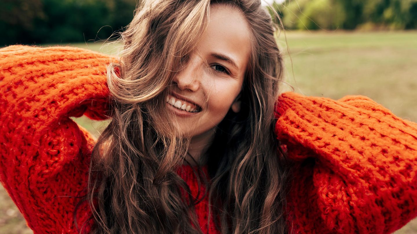 A young woman wearing a knitted orange sweater