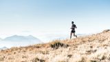 Ein Mann joggt in einer Berglandschaft.