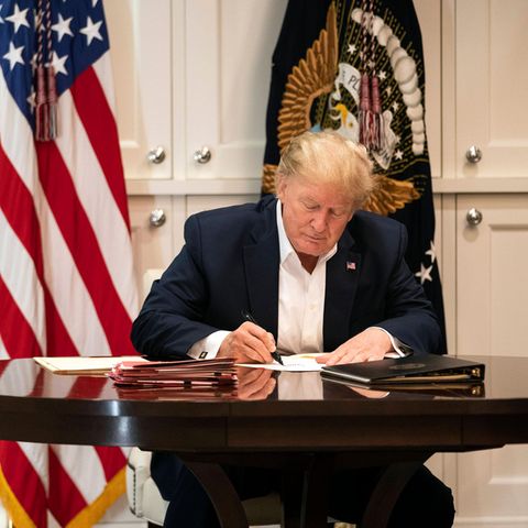 Donald Trump schreibt auf einem Blatt Papier